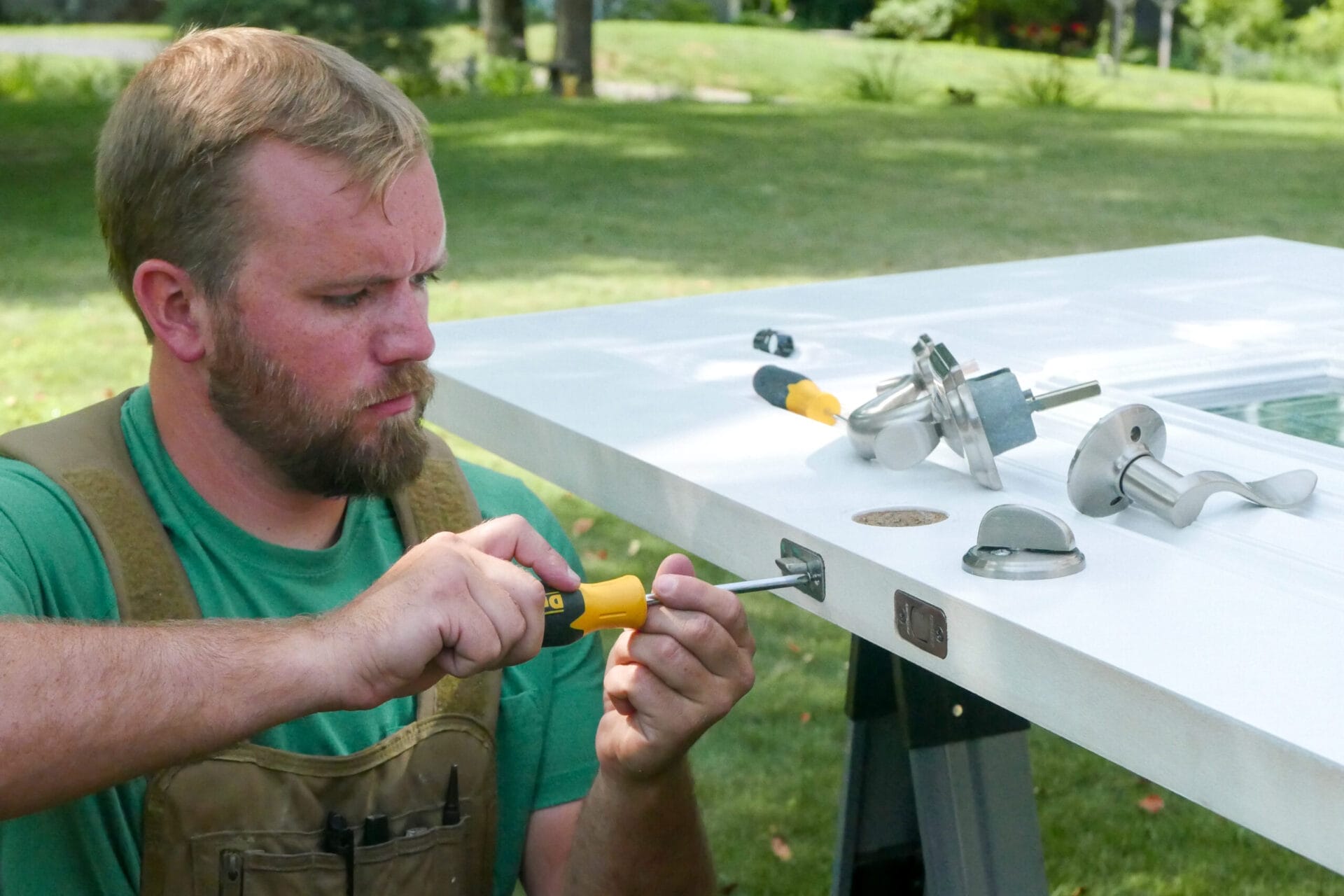 Nathan Gilbert adjusting the hardware on a front door.