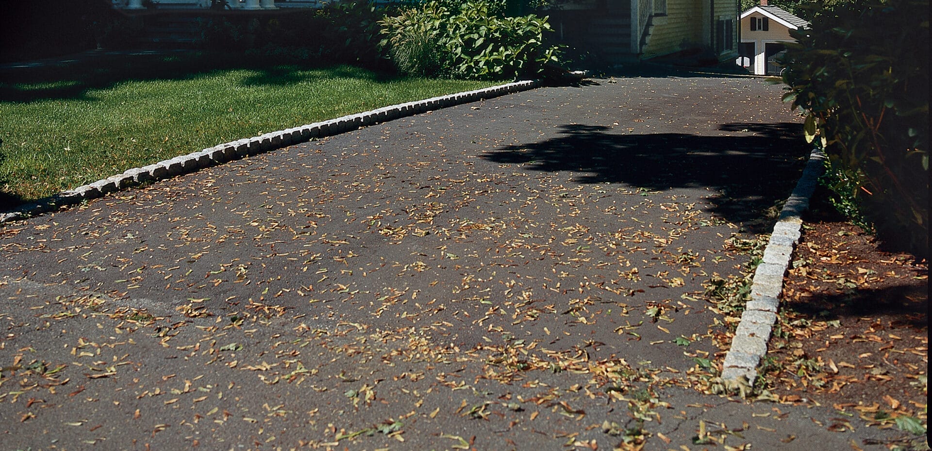 A belgian brick driveway leading up to a house.