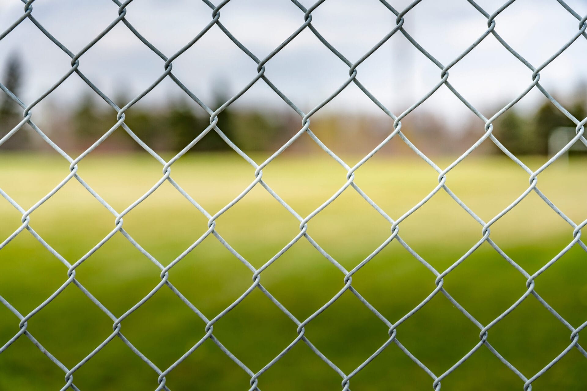 A chain link fence in front of a field
