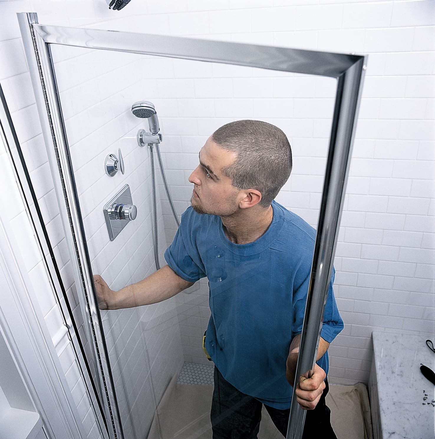 Photo of a worker installing a shower door