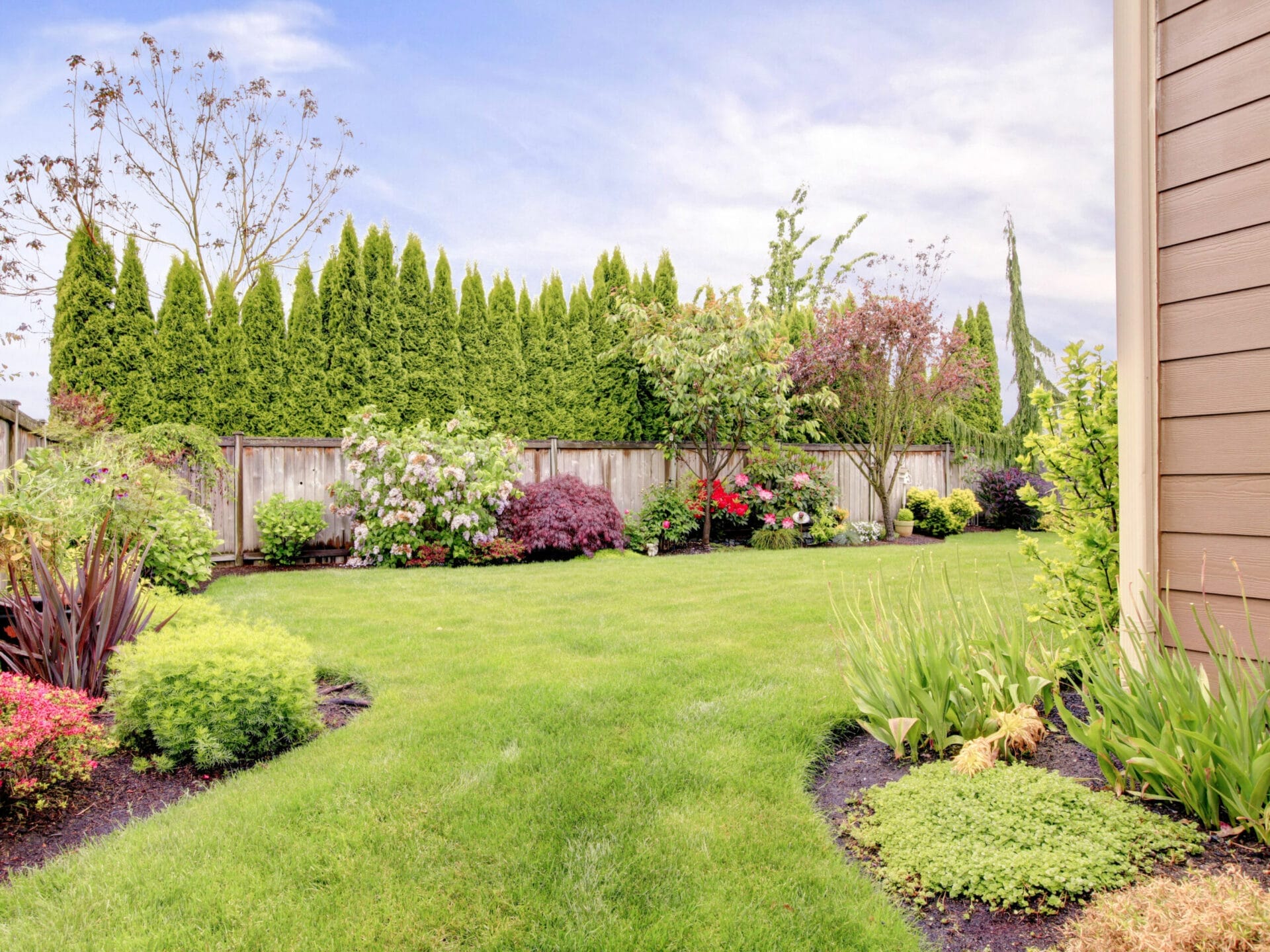 Landscaping-iStock-498015683.0 A landscaped yard with multiple gardens and trees.