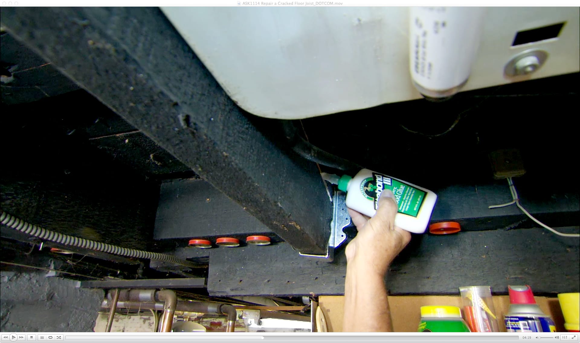 A man applying glue to a cracked joist.